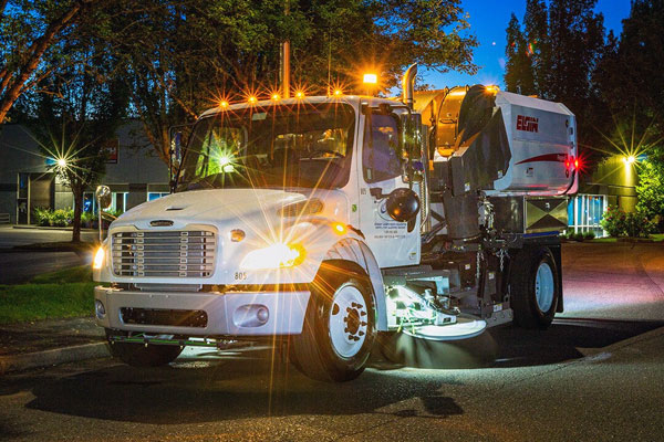 elgin street sweeper on a street at night